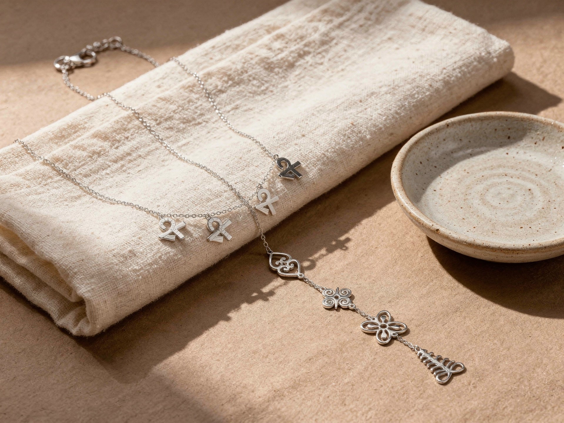 SHEN silver charm necklace on folded linen